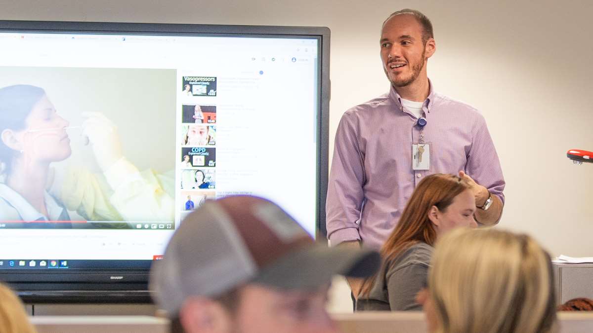A faculty member teaches students in the skills lab.