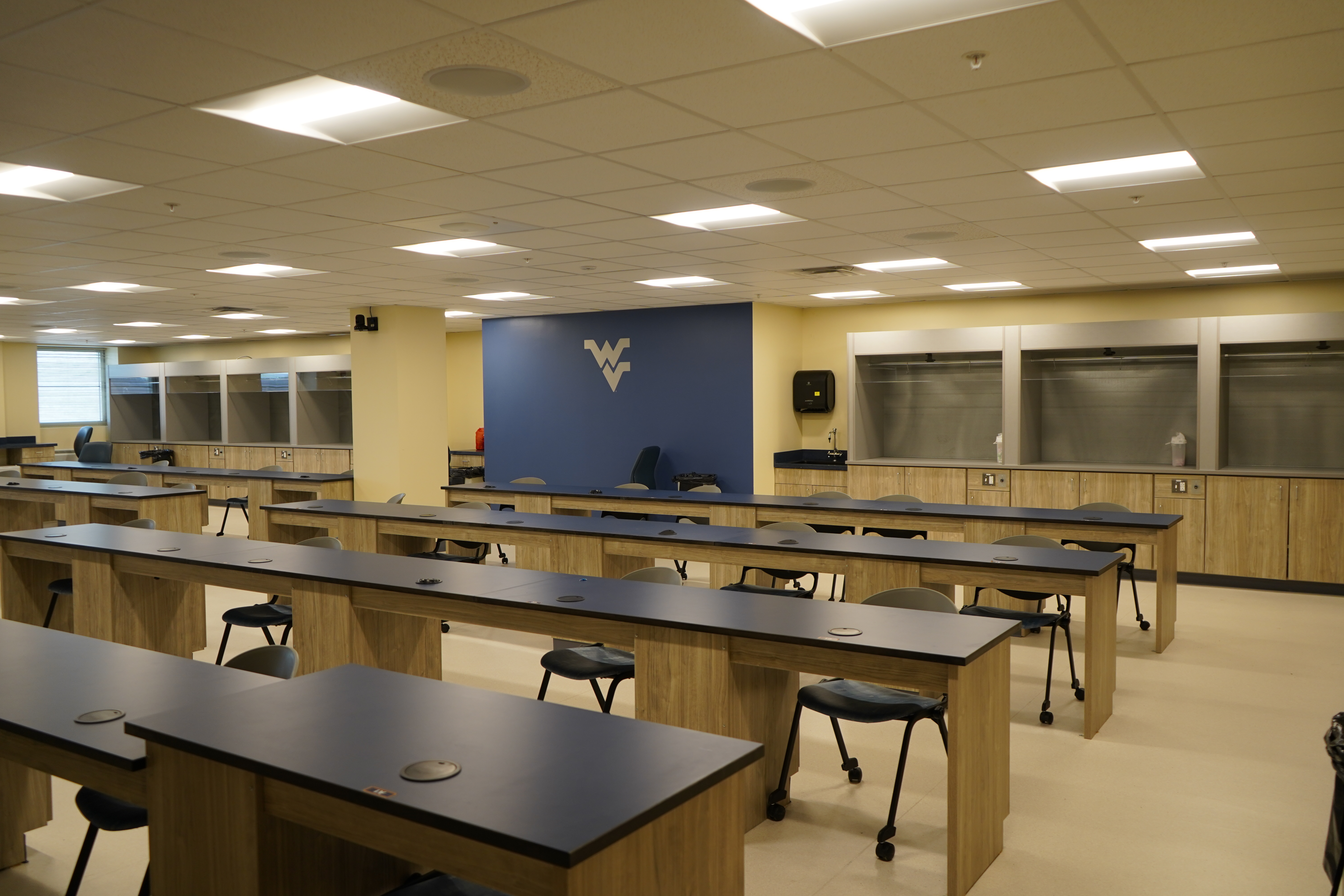 Empty classroom with long tables and chairs.