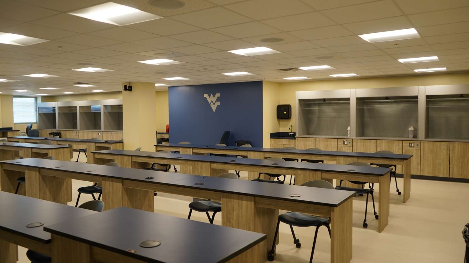 Empty classroom with long tables and chairs.